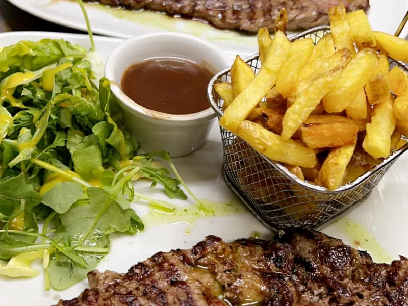 Entrecôte grillée servie avec frites et salade